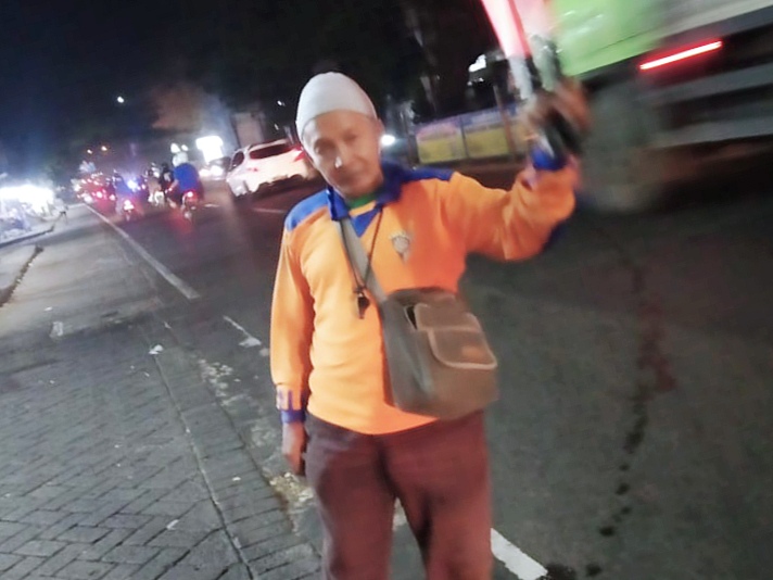 Imam Suyanto atau yang akrab dipanggil Imam Unyil terlihat sibuk mengatur kelancaran lalu lintas di jalan keluar-masuk SPBU Karanglo. Itulah keseharian pria bertubuh mungil itu untuk mengais rejeki.