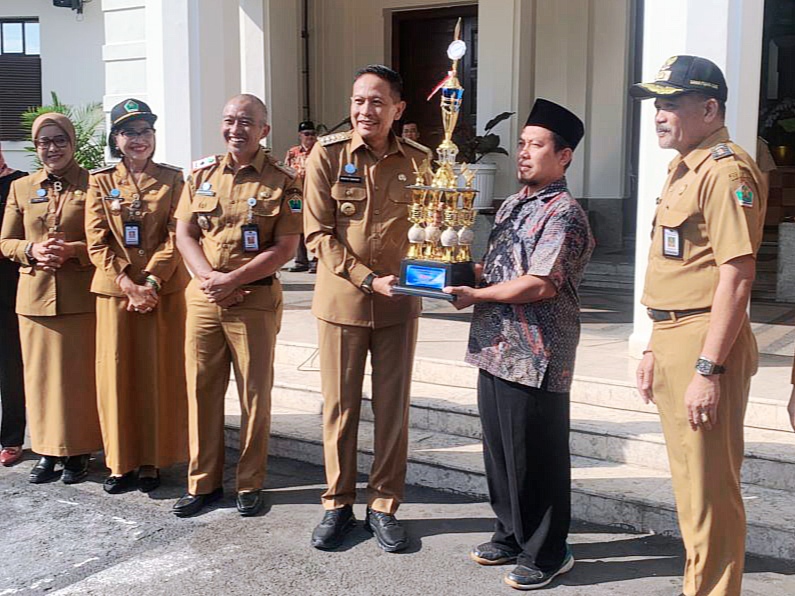 Wali Kota Malang, Dr. Ir. Wahyu Hidayat, menyerahkan piagam penghargaan kepada para pemenang Lomba Kampung Mbois, dalam upacara yang digelar di halaman depan Balai Kota Malang, Senin (5/5/2025)