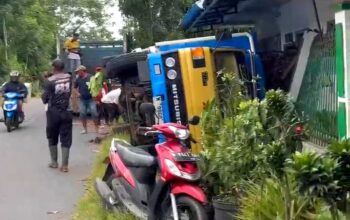 Sebuah truk pengangkut tebu terguling di Desa Jenggolo, Kecamatan Kepanjen, Kabupaten Malang. Truk terguling dan menimpa pagar rumah warga akibat jalan yang ambles di sisi bahu jalan, Senin (2/6/2025)