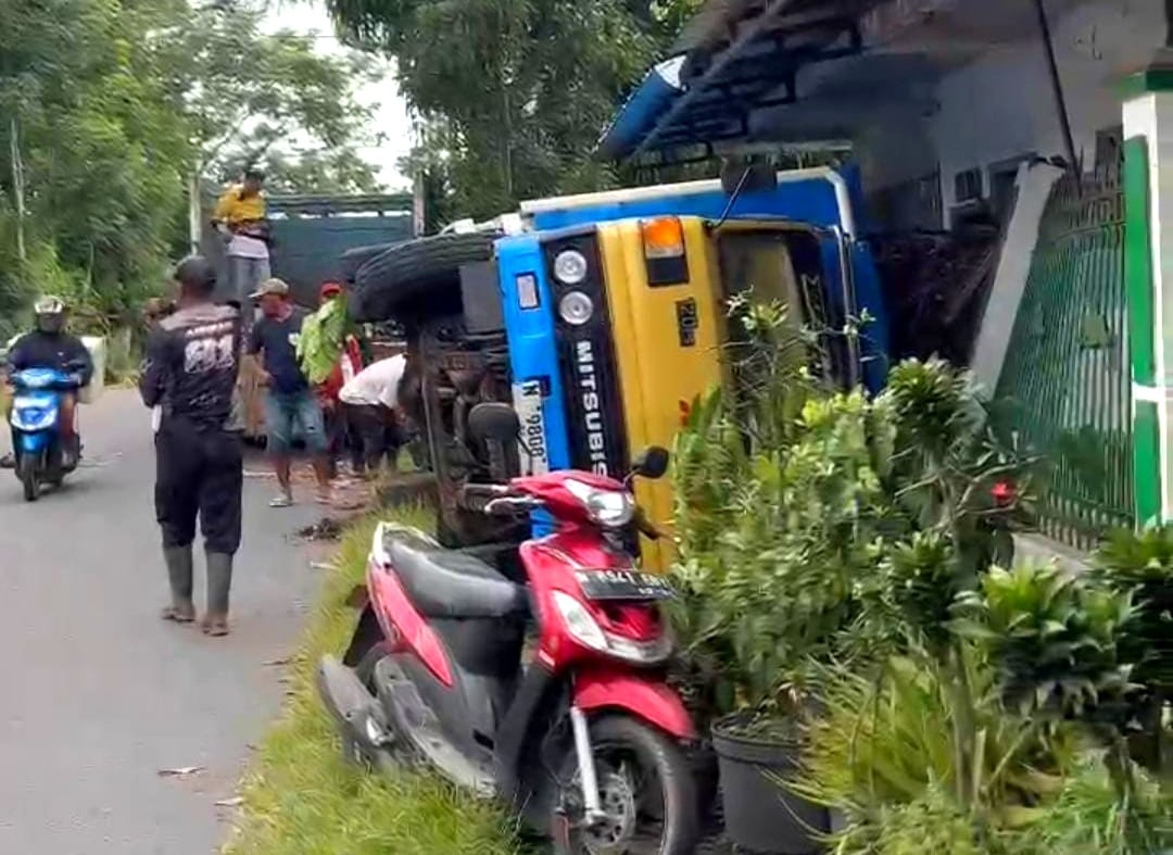 Sebuah truk pengangkut tebu terguling di Desa Jenggolo, Kecamatan Kepanjen, Kabupaten Malang. Truk terguling dan menimpa pagar rumah warga akibat jalan yang ambles di sisi bahu jalan, Senin (2/6/2025)