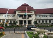 Di tengah geliat pembangunan Kota Malang yang kian dinamis, sebuah bangunan bergaya kolonial tetap berdiri anggun di kawasan Tugu. Gedung Balai Kota Malang, yang kini menjadi pusat pemerintahan kota, menyimpan sejarah panjang yang tak banyak diketahui warga, termasuk kisah tentang jam raksasa yang pernah menghiasi fasad timurnya.