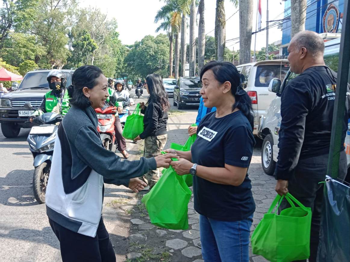 Jaringan Kemanusiaan Jawa Timur membagikan singkong, kunyit, kopi dan sanitizer kepada pengguna jalan dan Ojek Online di sepanjang Jalan Bondowoso depan Kampus Universitas Katolik Widya Karya sebagai sosialisasi membangun imun tubuh, Rabu (11/6/2025).